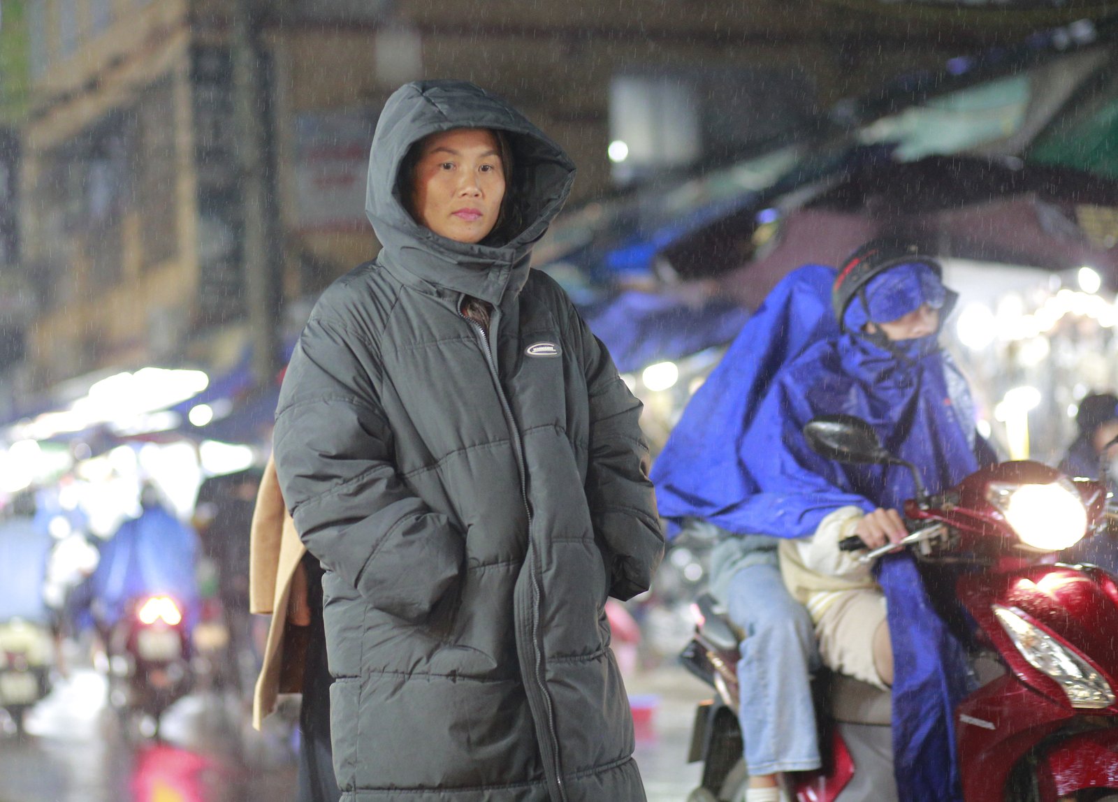 Travellers in light jackets walking down a Hanoi street on a cool winter day