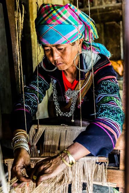 A Hmong woman weaving hemp cloth on a wooden loom in northern Vietnam