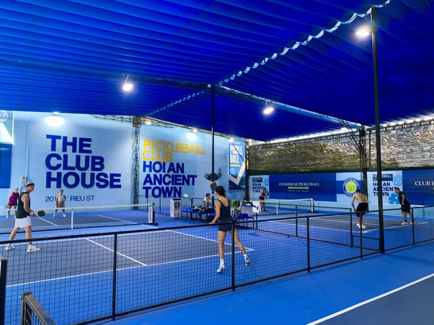 Players on the covered courts at The Club House pickleball club in Hoi An
