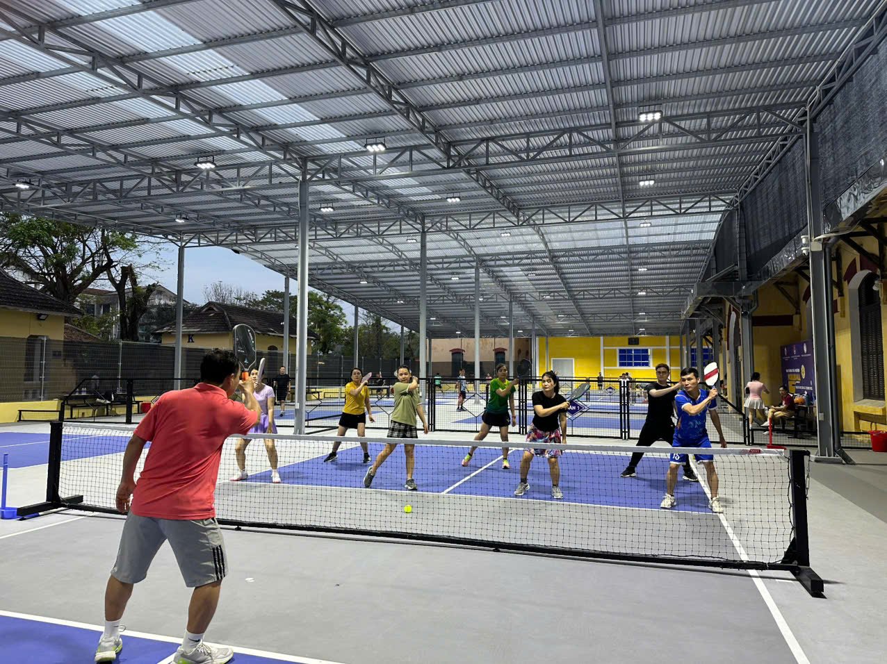 Players on a covered pickleball court in Hue early in the morning