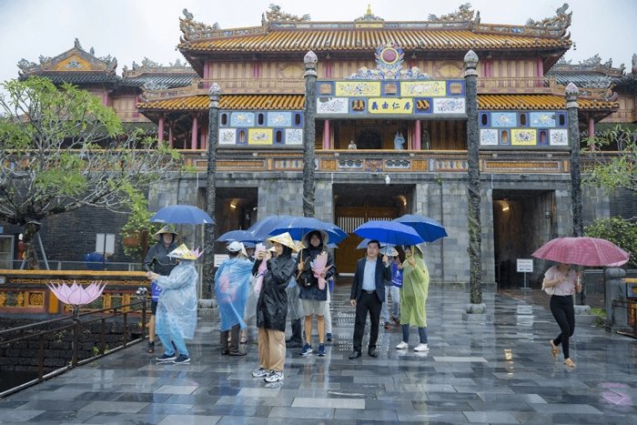 Visitors with umbrellas at the Citadel in Hue on a rainy day