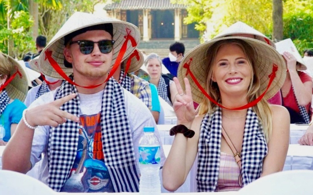 Smiling travellers in light summer clothes and conical hats in southern Vietnam