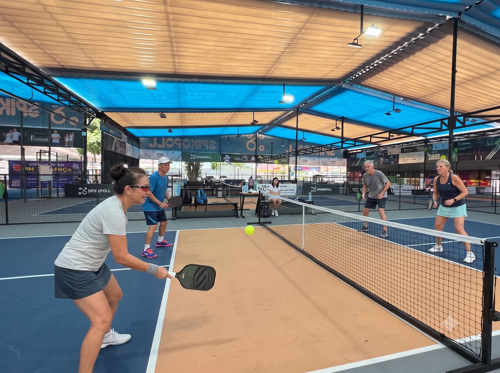 Older foreign and Vietnamese players together on a pickleball court in Vietnam
