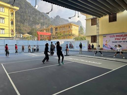 Local players filling a pickleball court in a small provincial town in Vietnam at dusk