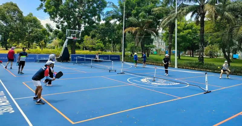 Sunny outdoor pickleball court in Saigon in January with palm trees