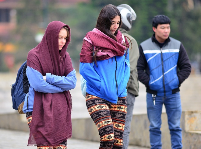 Travellers in jackets on a cold, misty morning in the mountains near Sapa
