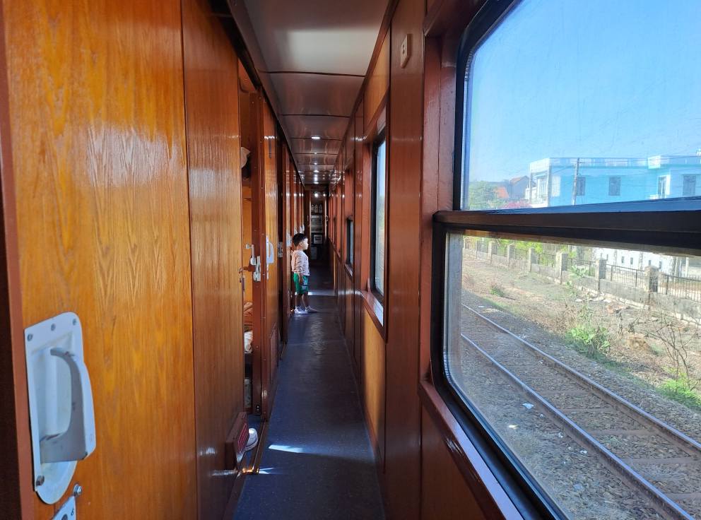 The narrow corridor of a sleeper train carriage with cabin doors along one side