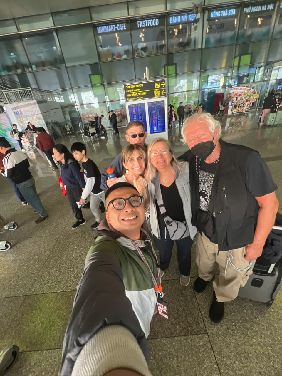 Older travellers met by a local guide at Noi Bai airport, Hanoi