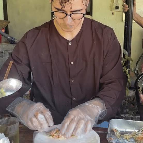 Hands rolling fresh Vietnamese spring rolls at a cooking class