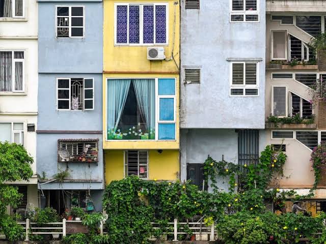 A row of tall, narrow Vietnamese tube houses on a residential street