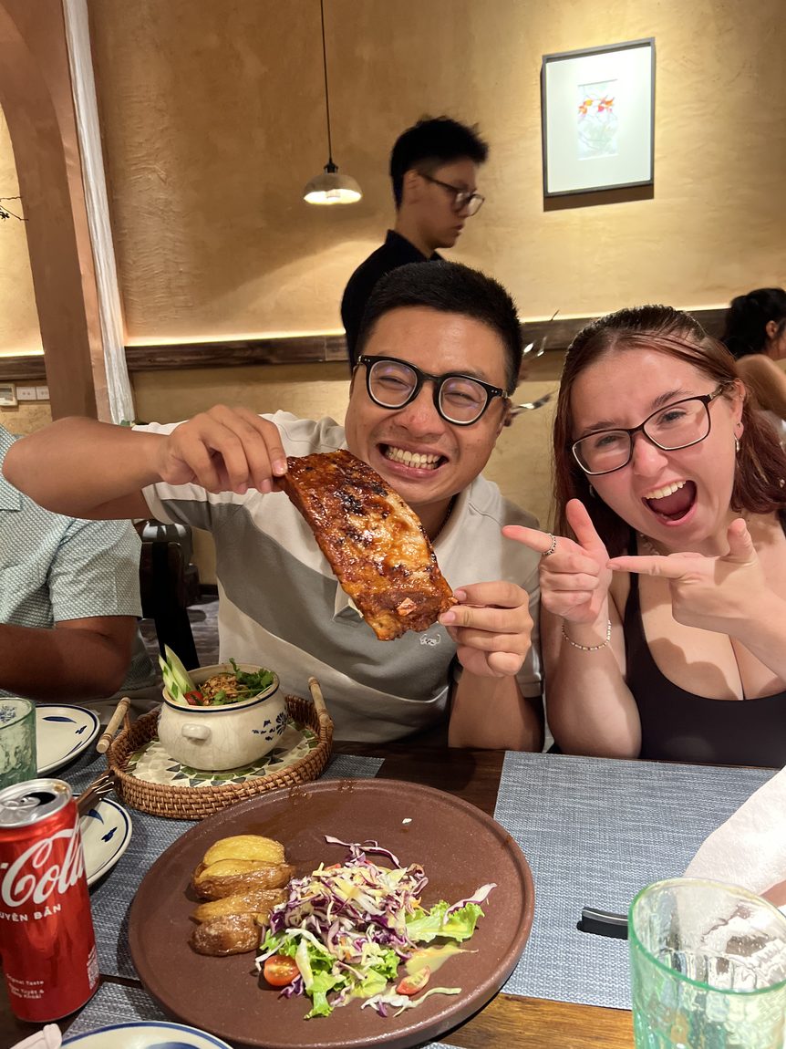 A couple laughing over a big plate of ribs