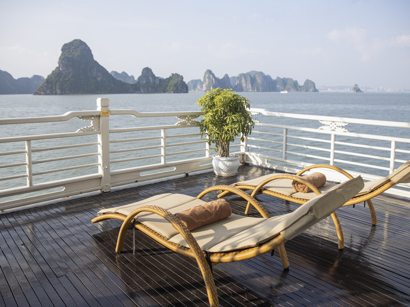 Sun deck aboard an overnight cruise looking out over Ha Long Bay's limestone karsts